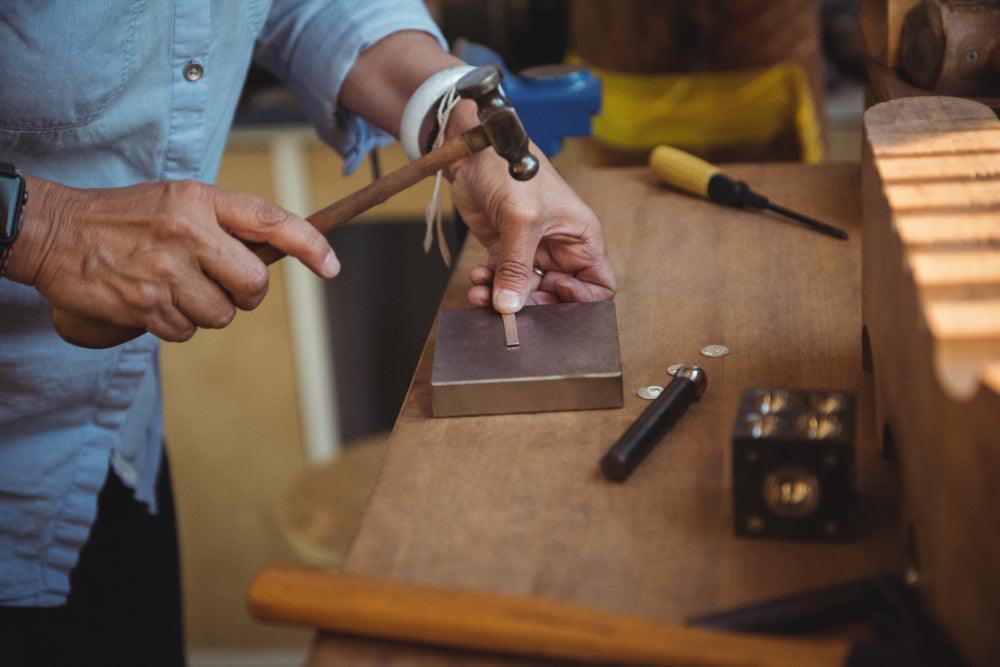 mid-section-craftswoman-using-hammer